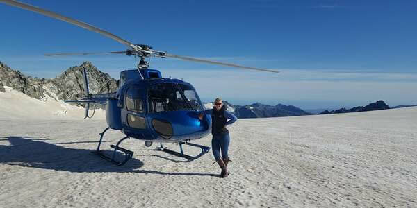 Megan McCarthy standing beside a blue helicopter.